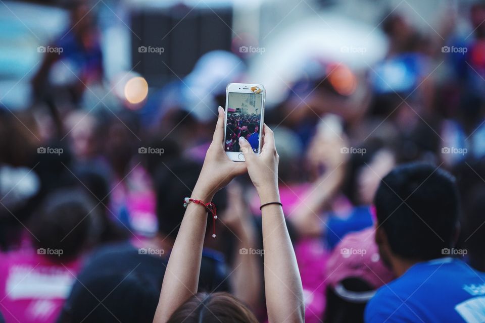 A young woman taking pictures on her phone