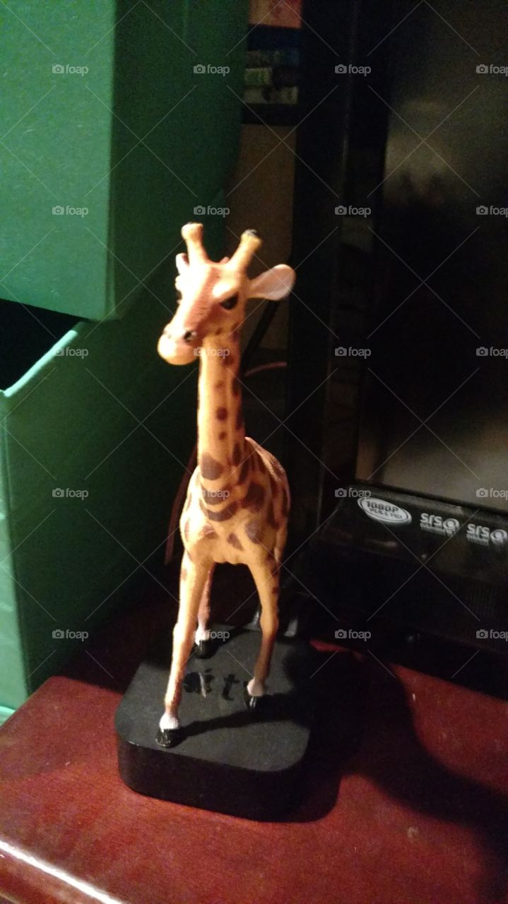 giraffe toy on TV stand