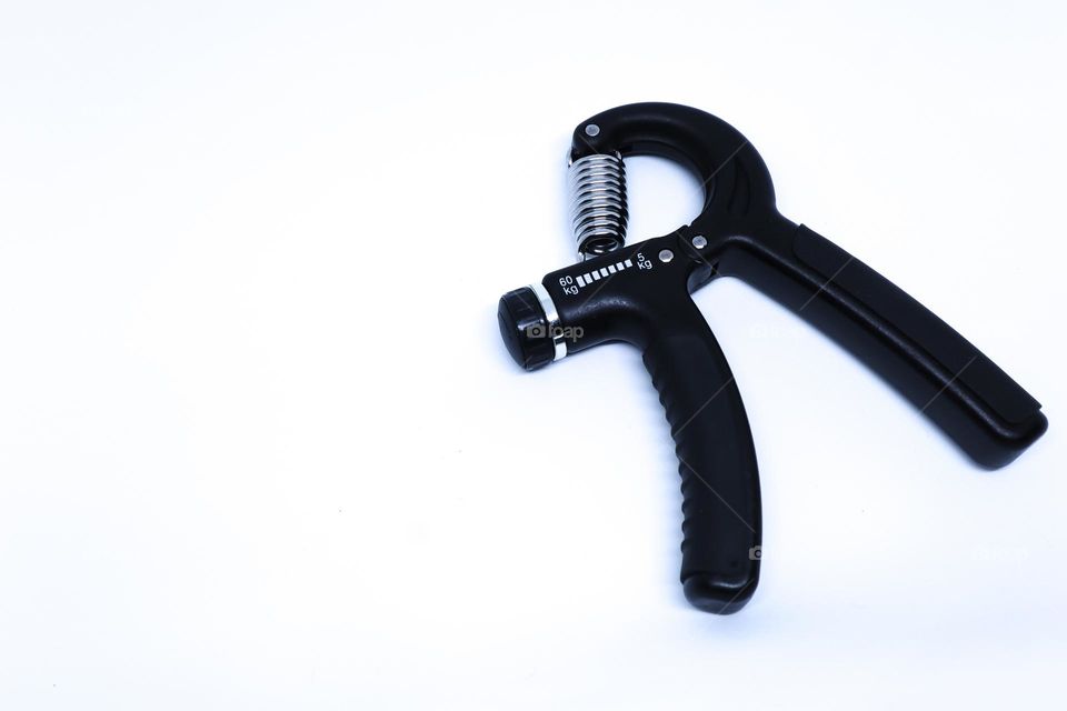 A Black Hand Grip Strengthening Tool in The Minimalist White Background with Oblique Top Shot, Landscape Mode