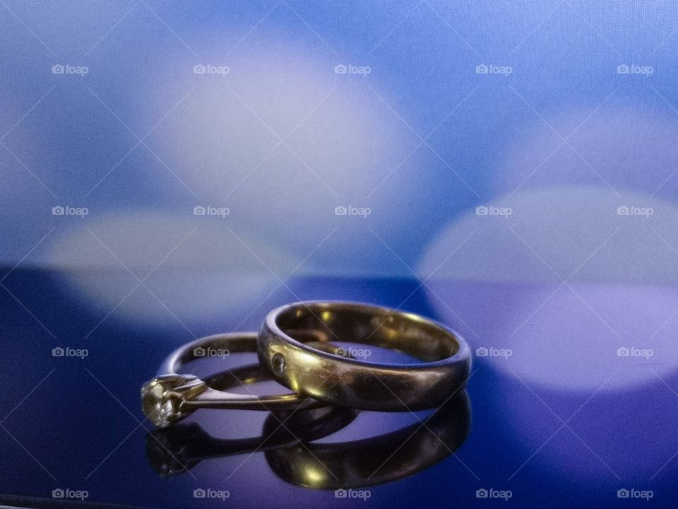 Wedding rings in beautiful warm light with purple background