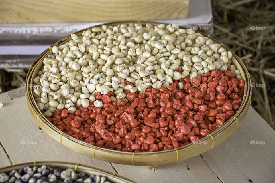 Seed corn in bamboo baskets on wooden table.