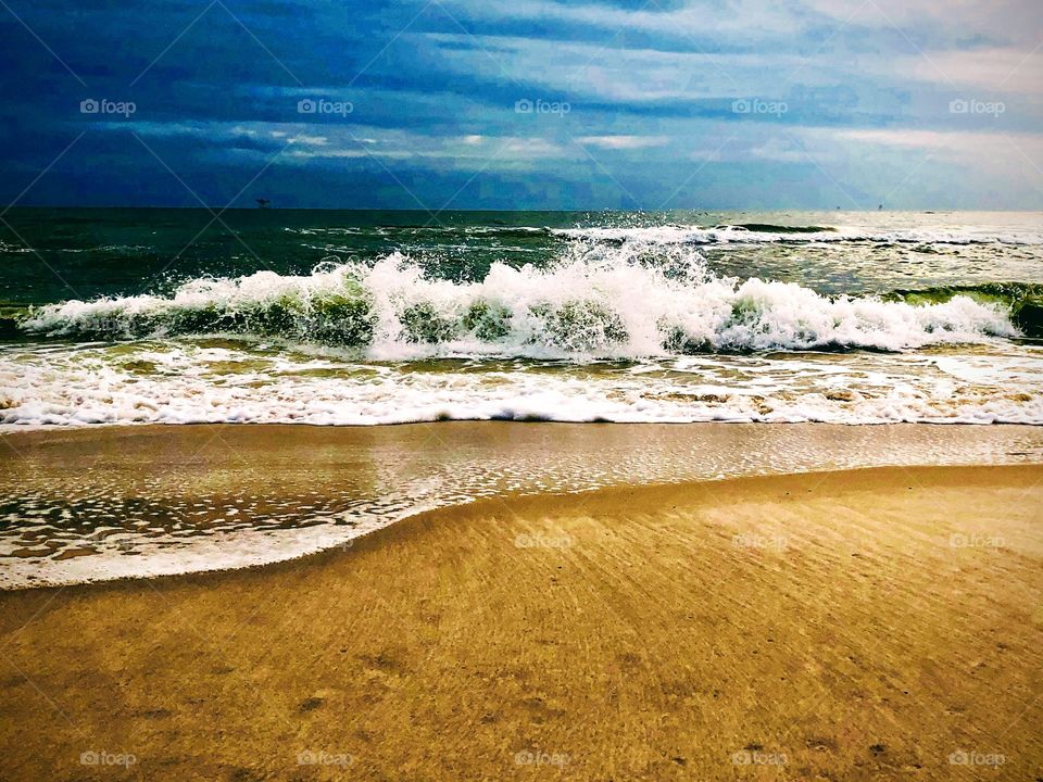 Waves crashing on the sand at the beach 