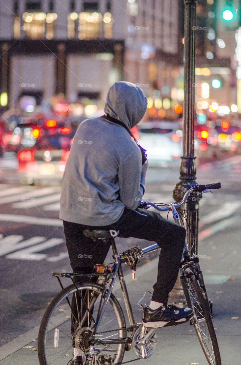 Rear of man sitting on bicycle in street