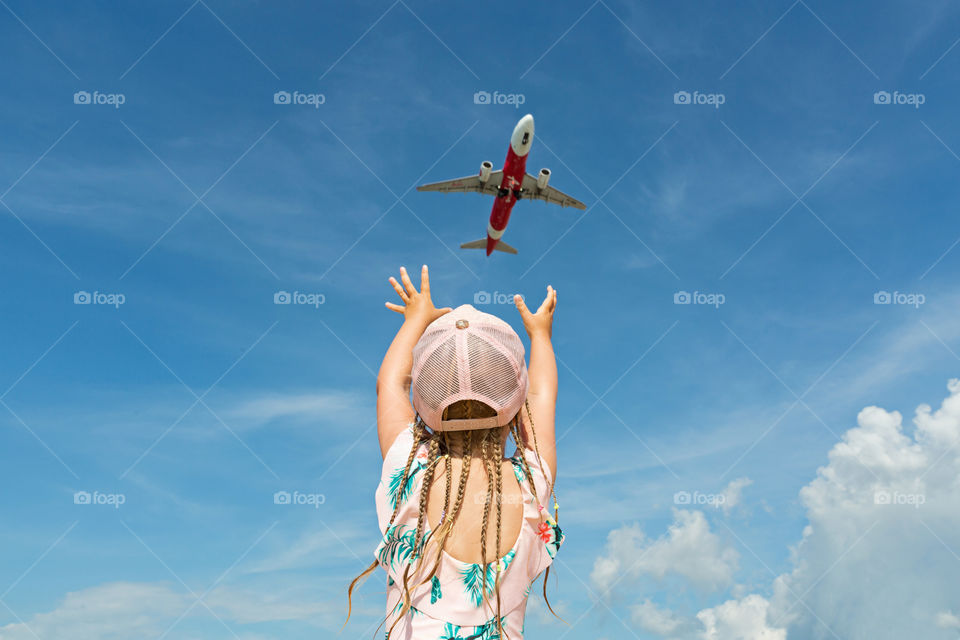 Girl from behind and aircraft in sky