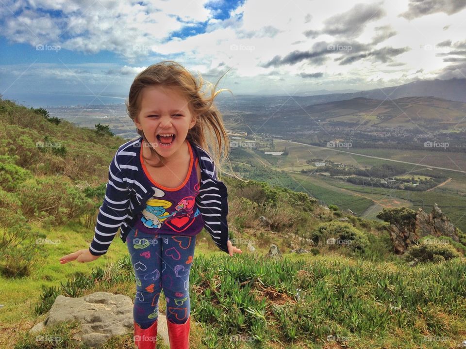 Young girl screaming on mountain top