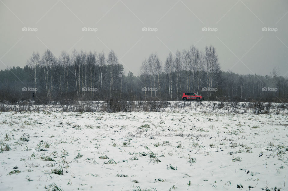 Winter landscape with a red car