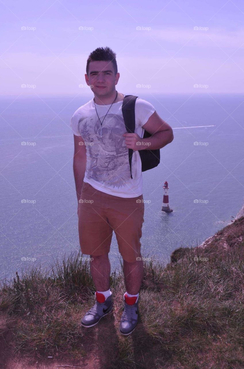 Man standing on cliff at seaside