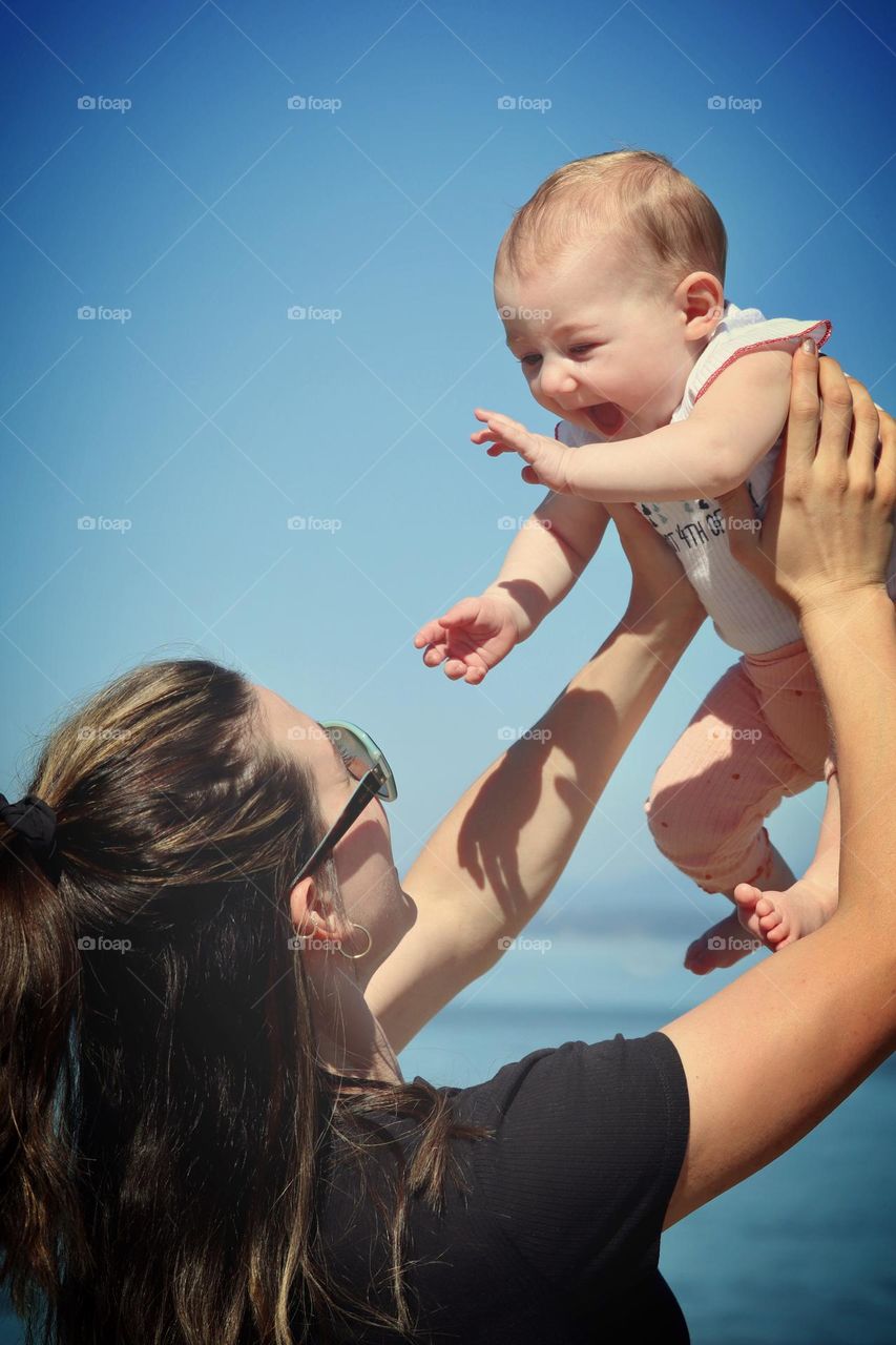 Mother and daughter enjoy the blue skies and sunshine of a summer day near the waterfront in Tacoma, Washington 