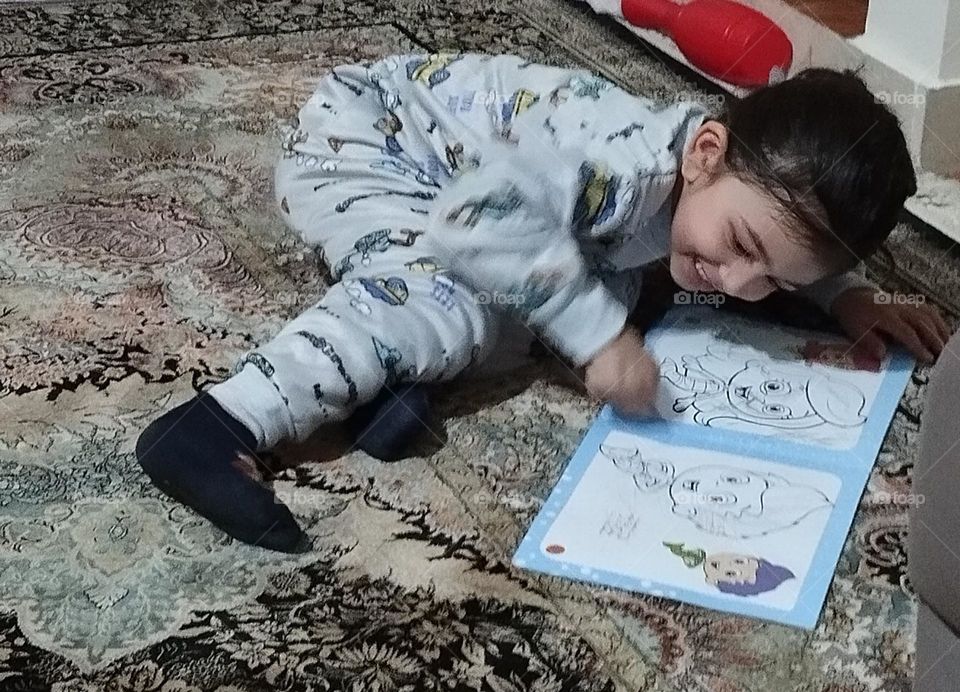 One of our class with each other at home is painting time . This time he was so eager for his new gift ,painting book so he didn't wait for table and chair and started painting happily so I took his photo and funny way of his sitting