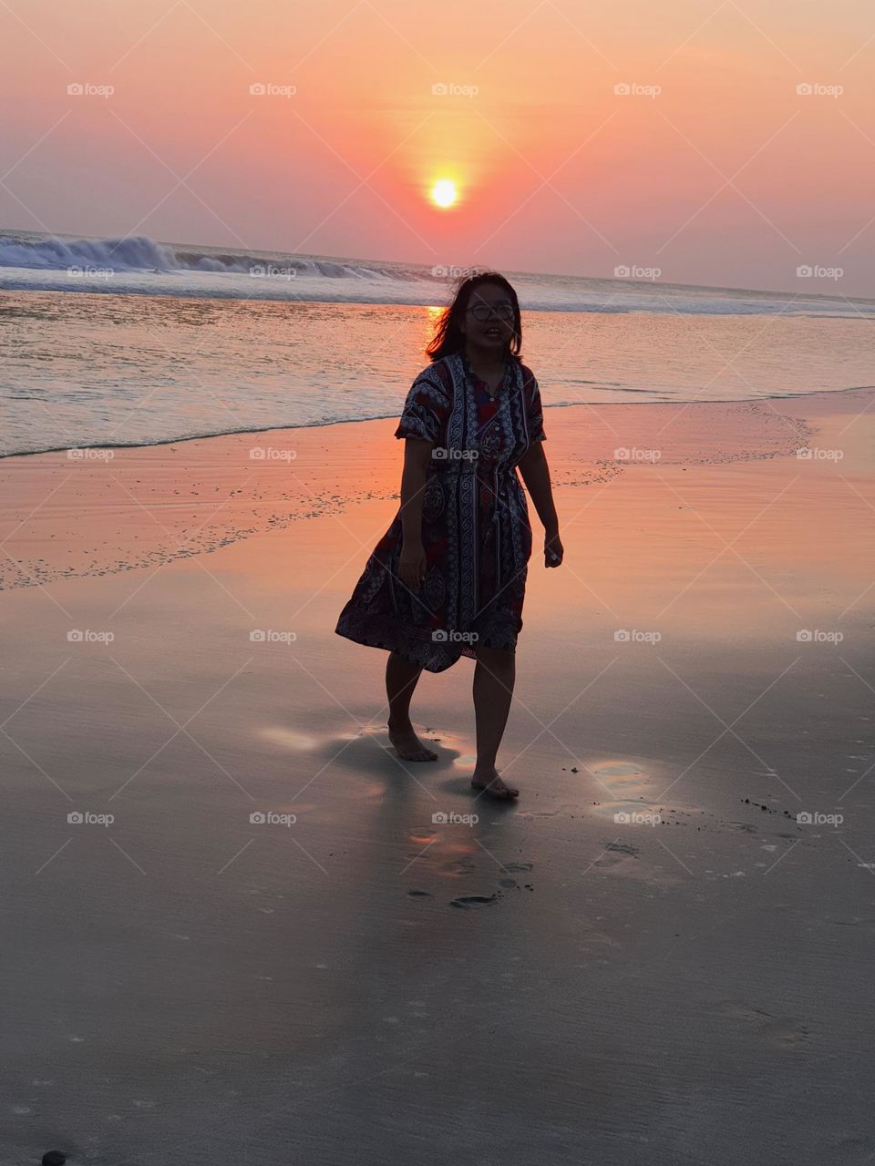 At sunset walking alone at the beach
