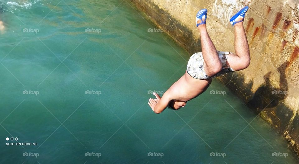 splendid jump into water at essaouira Harbour in Morocco.