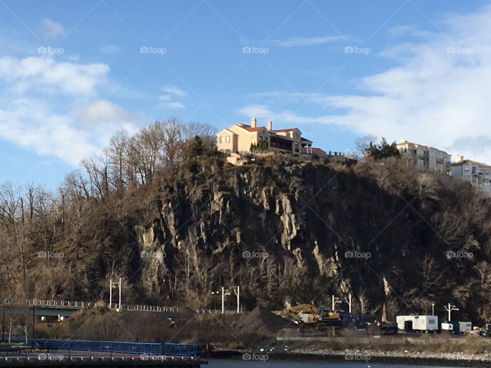 Home on the Palisade cliffs above Hudson River with cirrus clouds in blue sky 