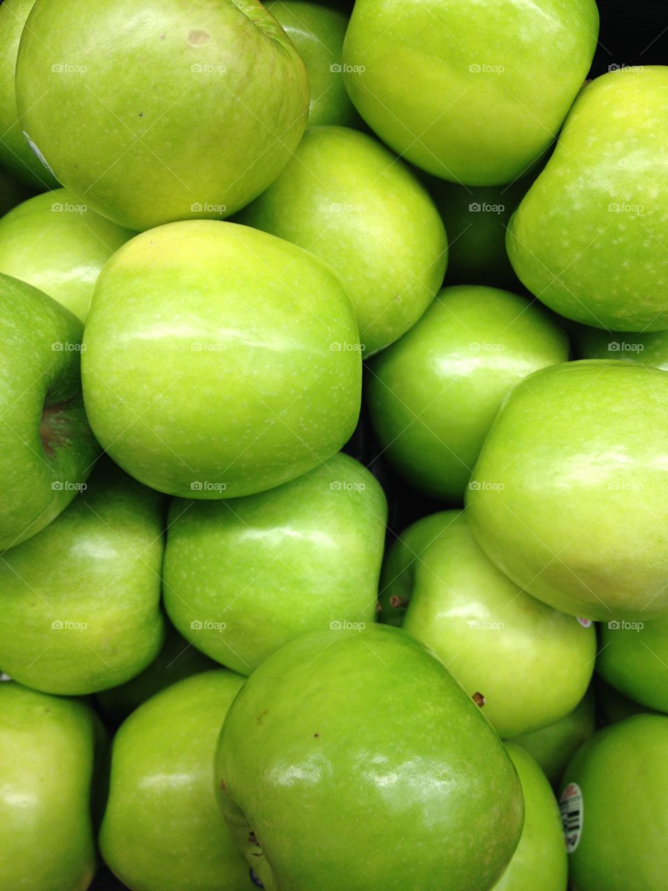 Green apples loose in bin at market.