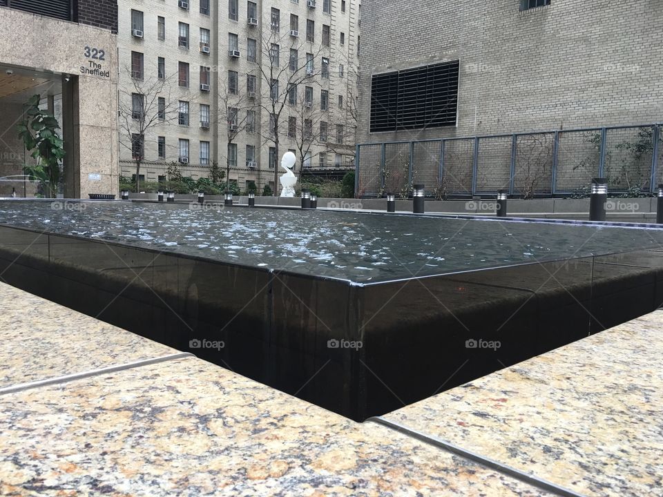 Water fountain/pool in the middle of a busy city