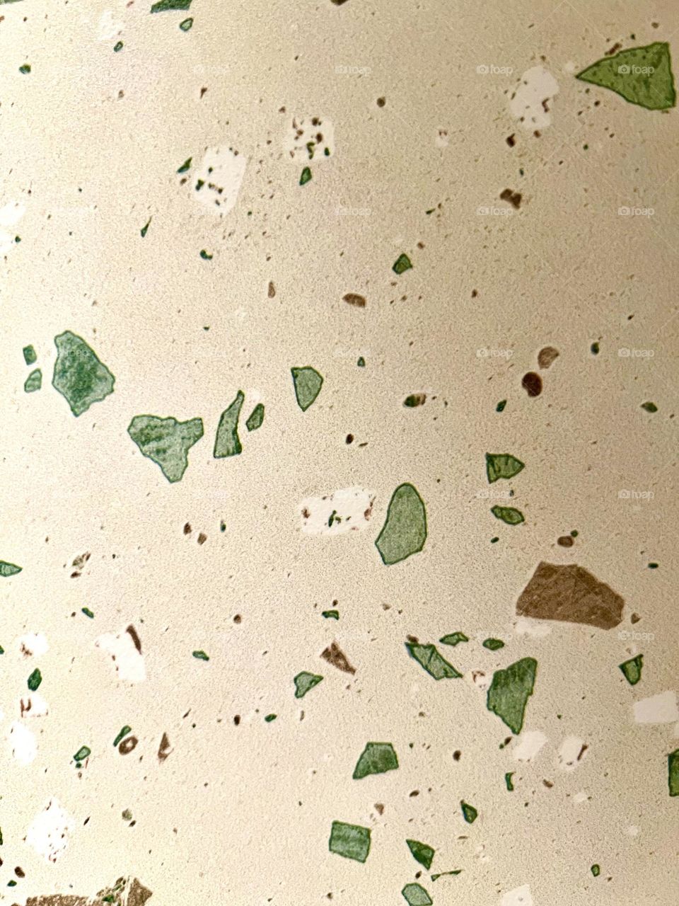 Terrazzo texture background - light surface with green, brown and white pebbles. Natural, modern and aesthetic material for design and interior