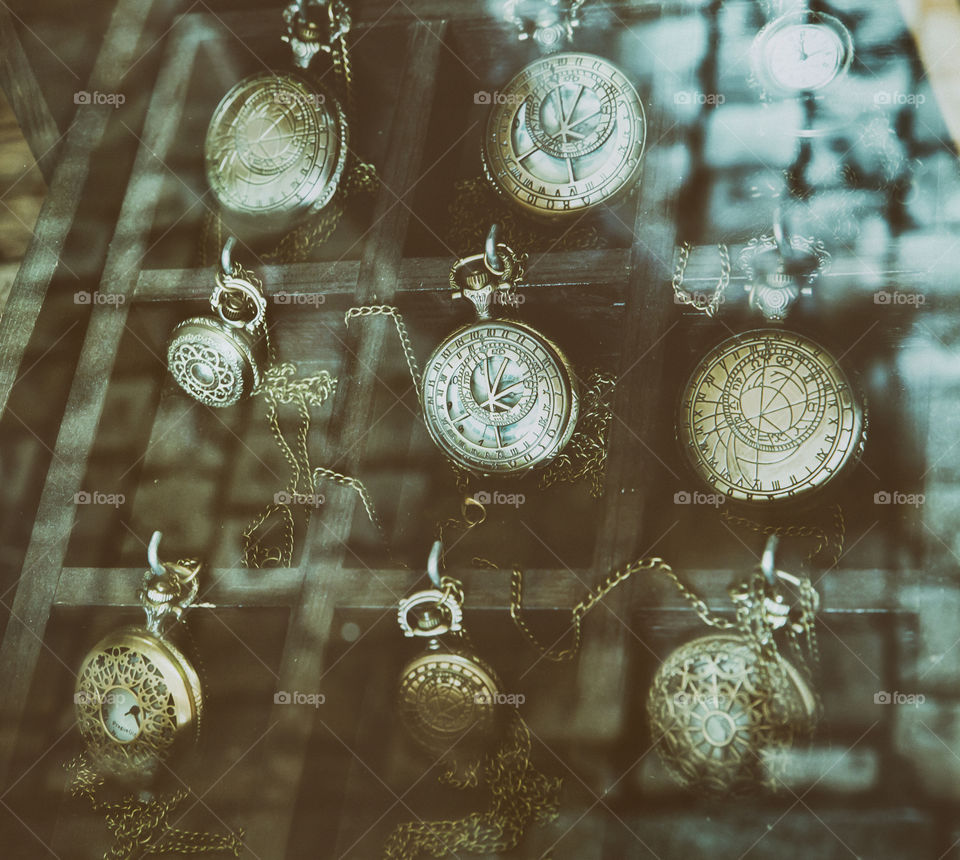 Antique round pocket watches behind the glass in the shop