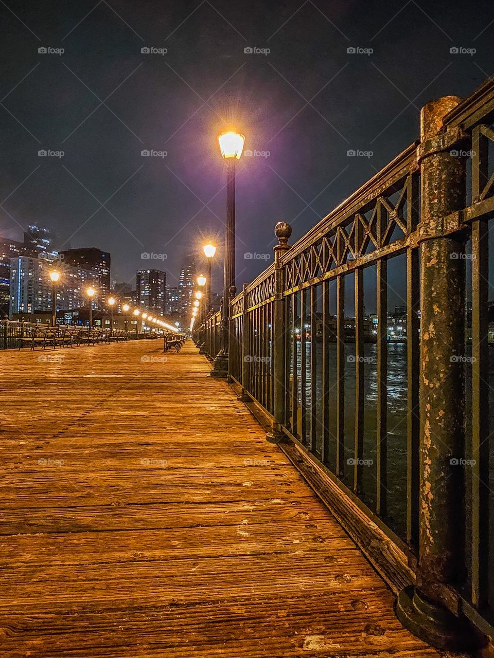 Evening on Pier 7 in San Francisco on the old vintage Victorian style architectural design with its intricate iron rails and light posts 