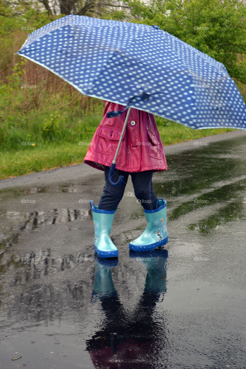 Girl standing with umbrella in rainy day