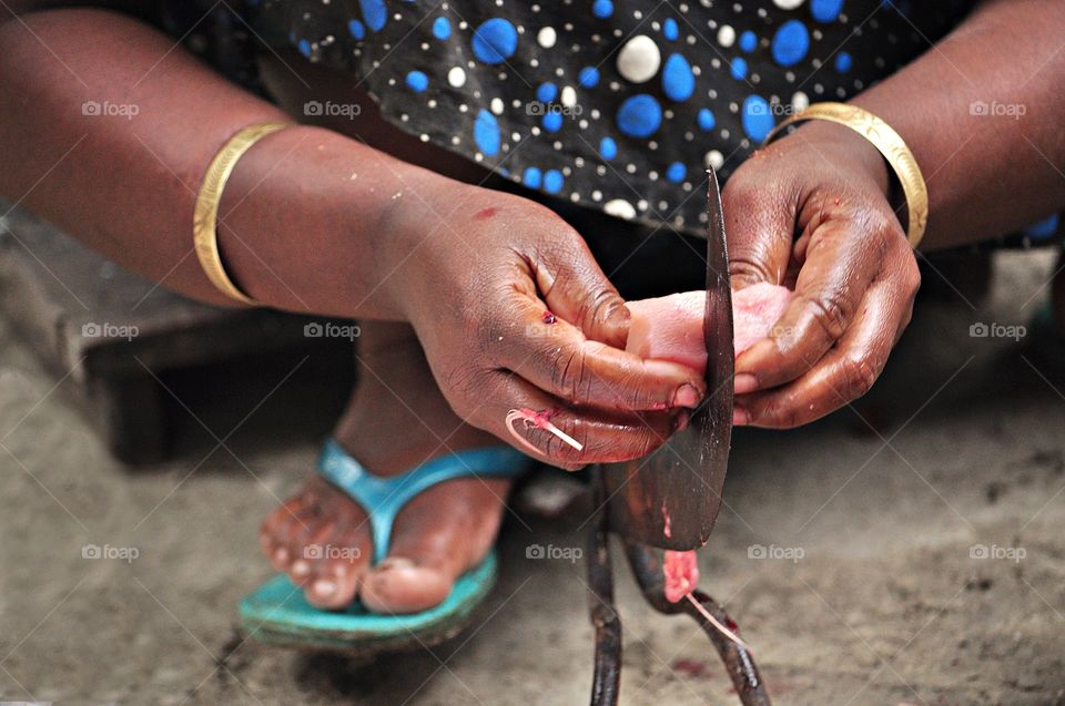 A lady was using an unique knife to cut the meat