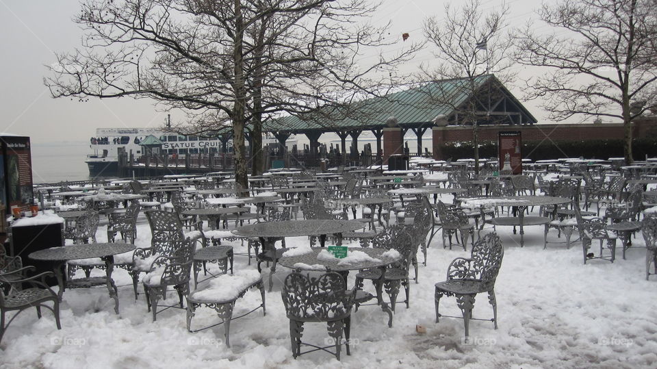 Tables and chairs covered with snow