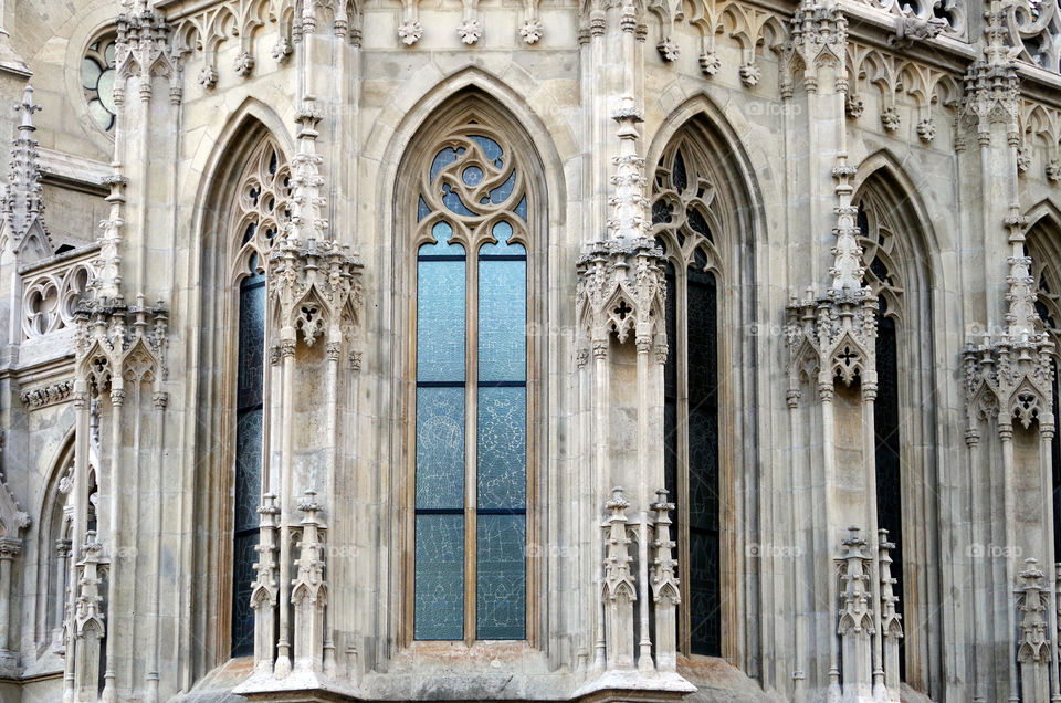 Building exterior with archs and rose windows in Budapest, Hungary.