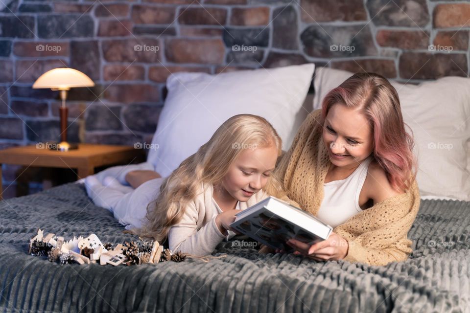 mom and daughter reading the book