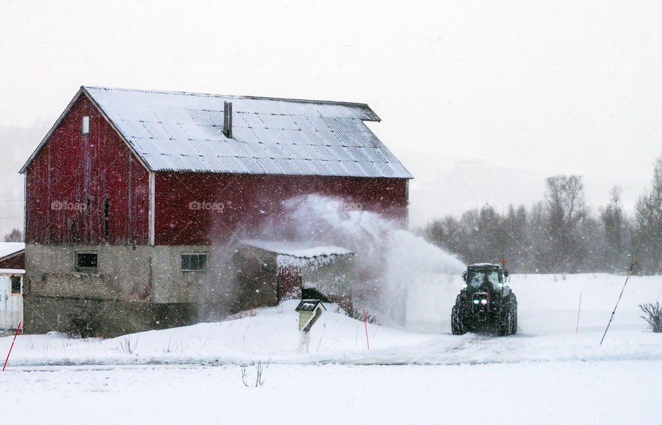 Shoveling snow with tractor. 