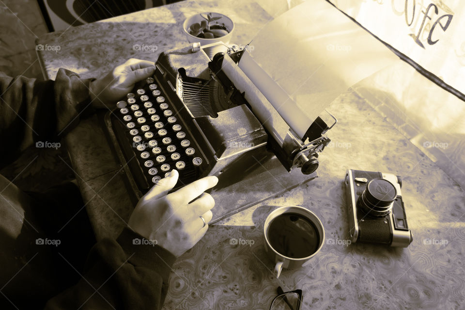 A young writer is writing a new book on an old typewriter.