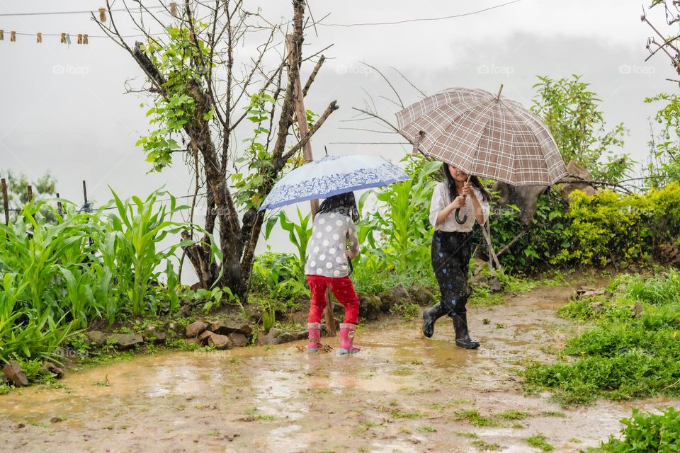 Siblings enjoying the rainy puddles in spring