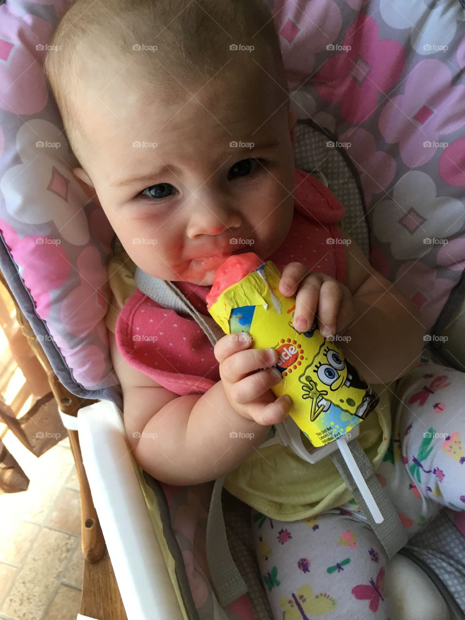 Elevated view of cute baby eating popsicles