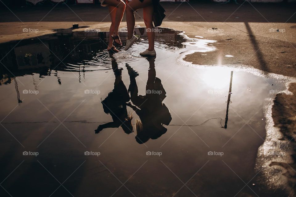 Dancing girl silhouette in water on sunset