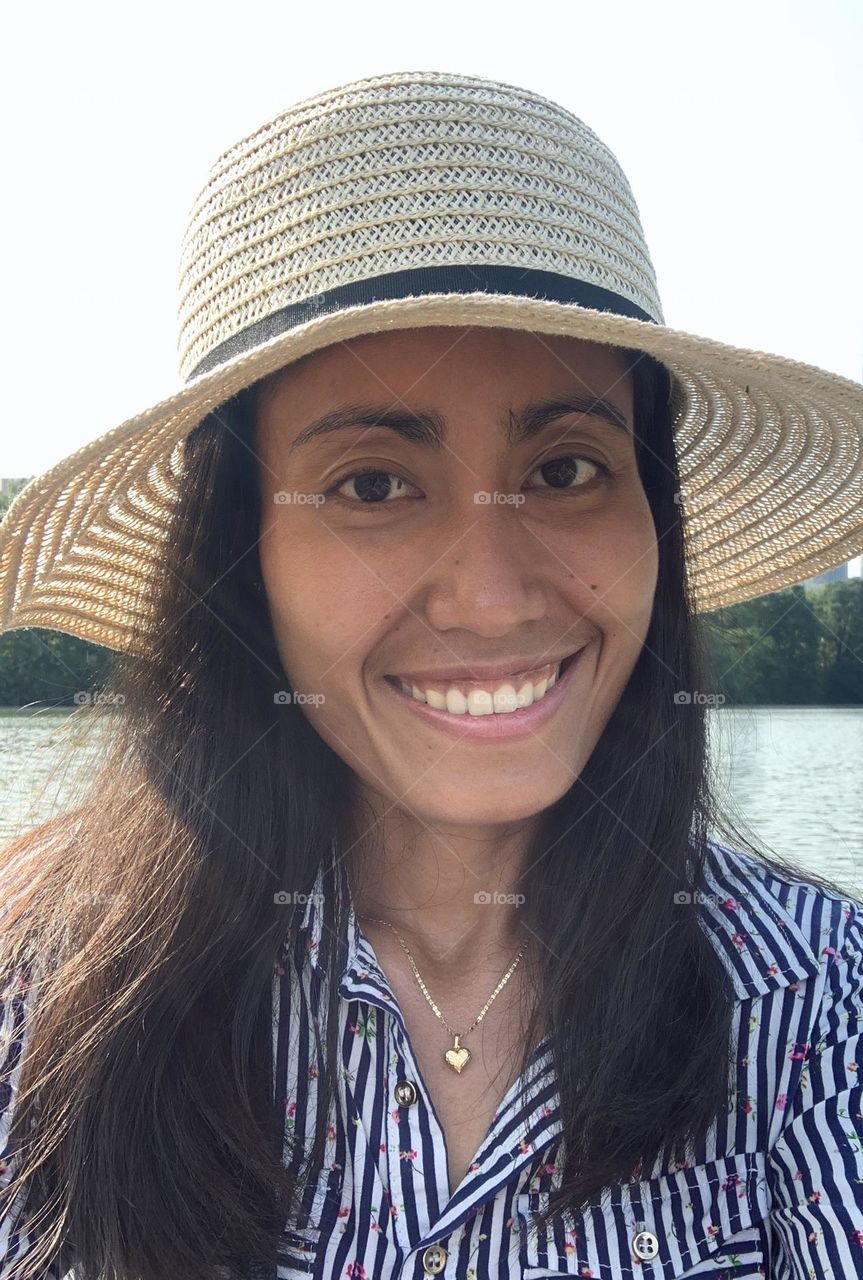 Portrait of a woman wearing hat, no make up with smiling face.