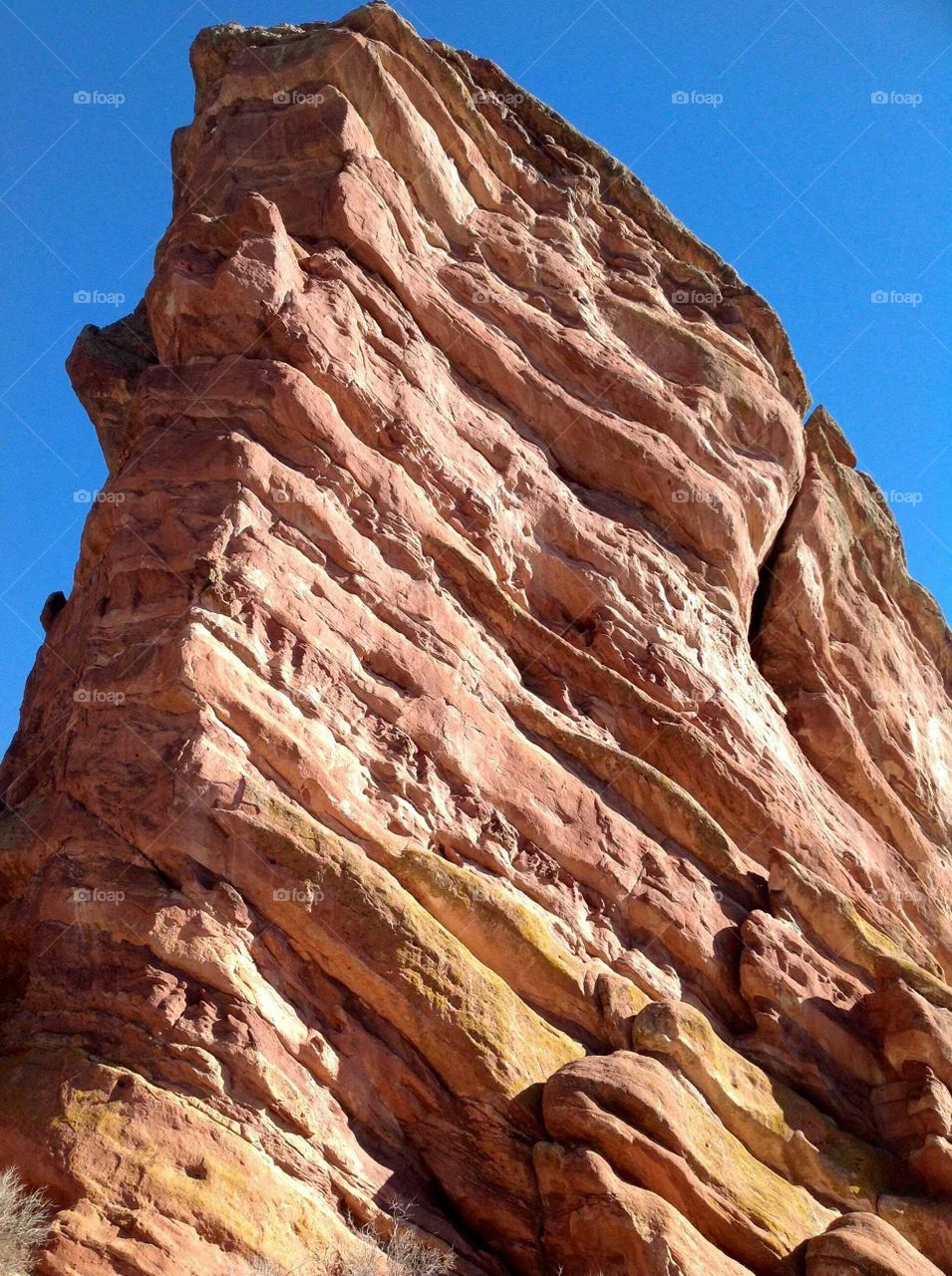 Close-up of red rock against blue sky