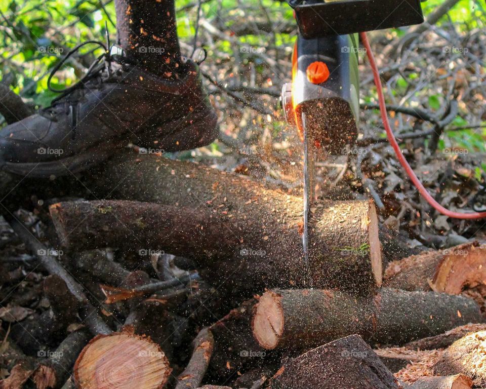 Cutting logs with an electric chainsaw
