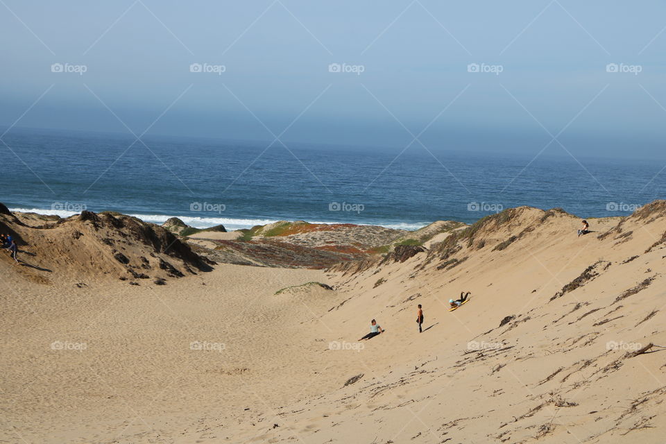 Kids playing on sand dunes, having fun , making memories 