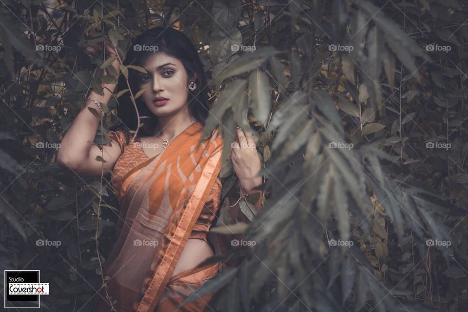 The girl is standing in the forest of leaves 