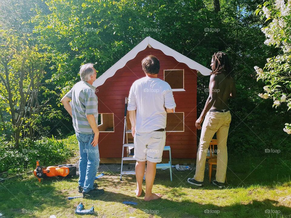 three men building a playhouse