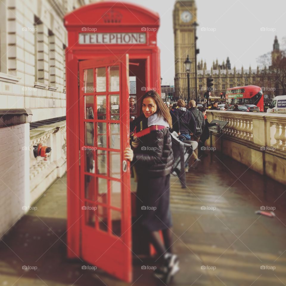 Woman smiling while entering phone booth