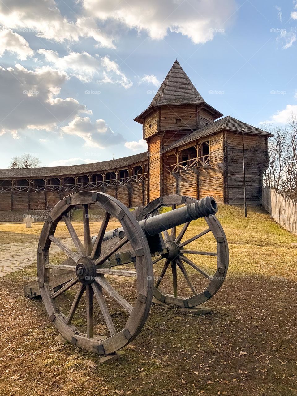 Citadel of ancient fortress, wooden castle tower and defensive wall, old gun on carriages