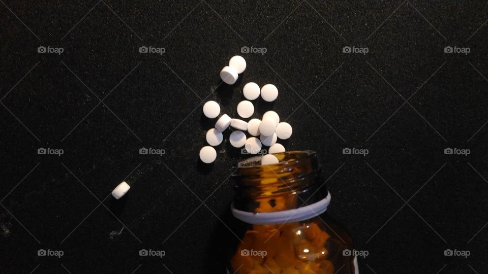 Tablets coming out of medicine bottle.