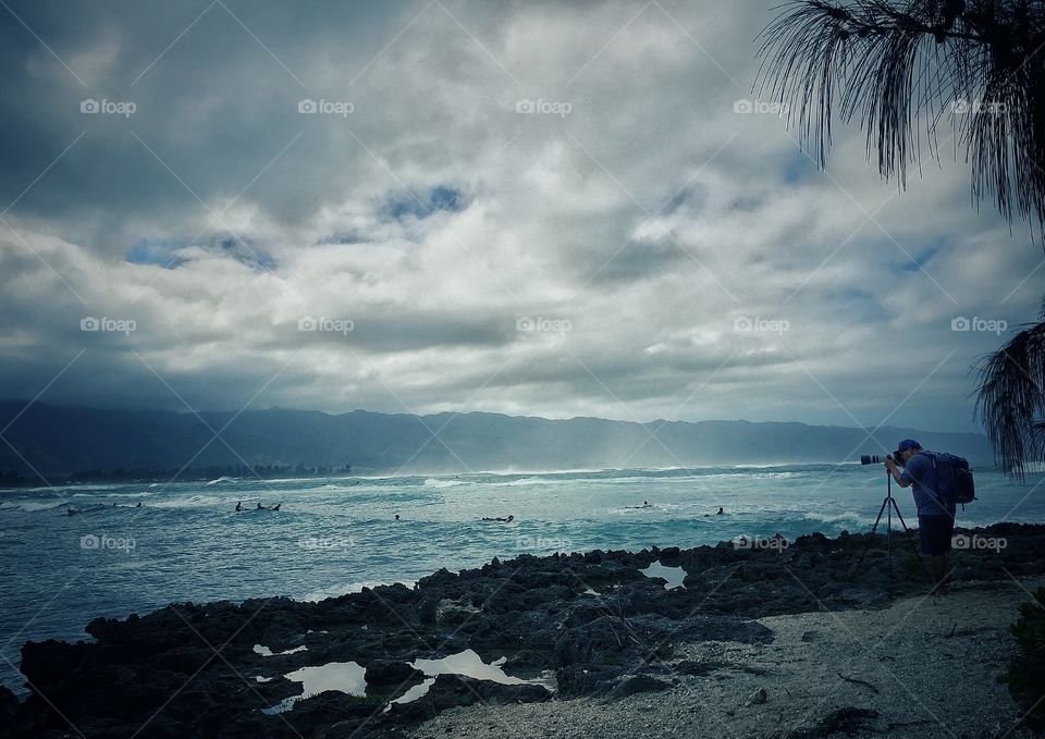 Photographer photographing surfers on the North Shore of Oahu