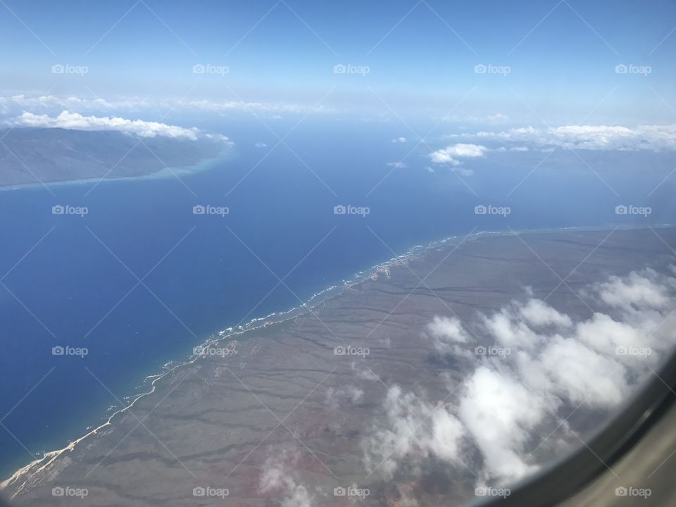 Sky view of Hawaiian islands of Molokai, Lanai City and Maui from airplane 