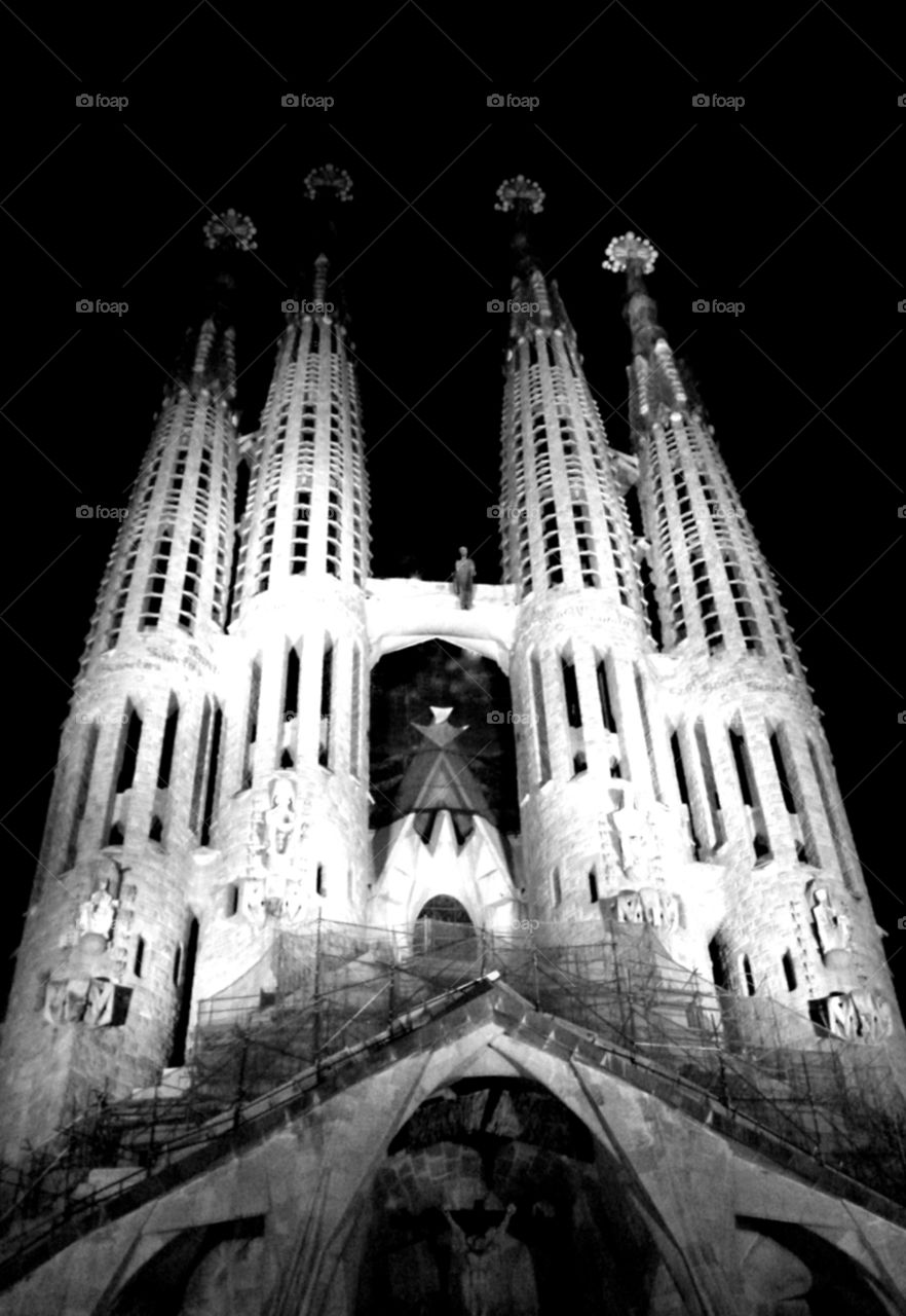 Gaudi's La Sagrada Familia in Barcelona Spain with an eerie glow in the night sky.