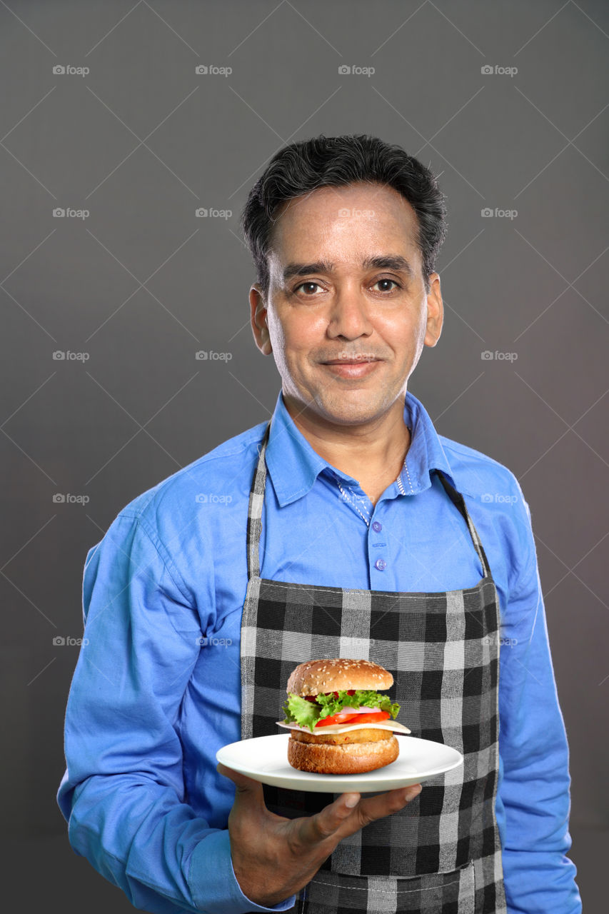 Indian man chef with a burger plate