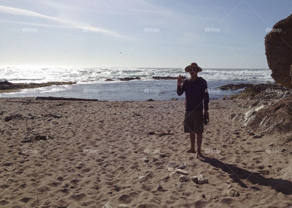 Man waving on the beach