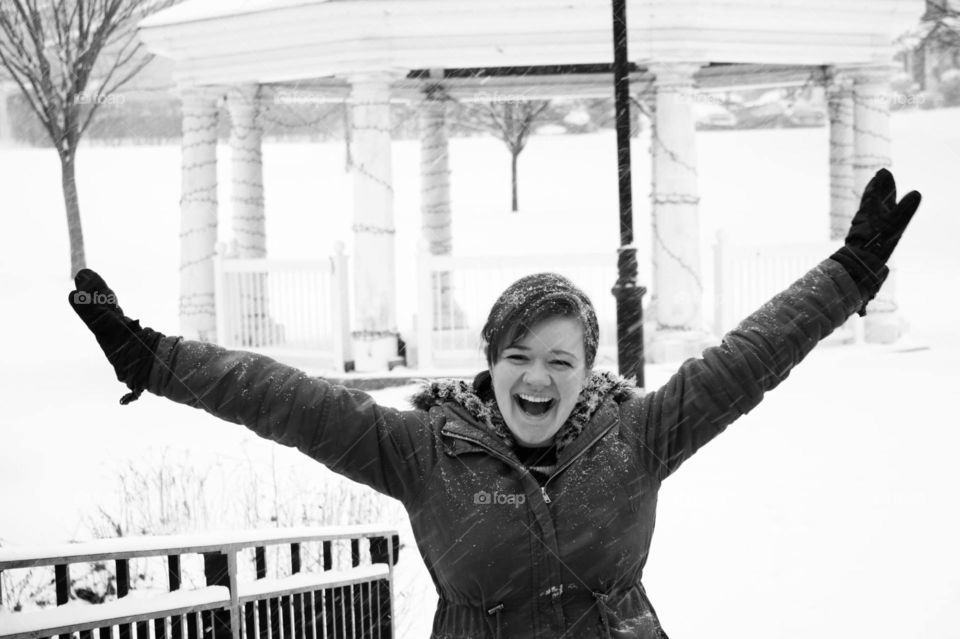 Smiling attractive young woman outside playing in the snow. Winter wonderland scene