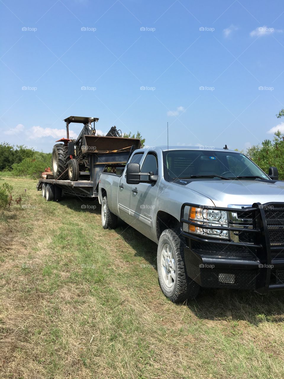 Truck and trailer loaded with a tractor. 