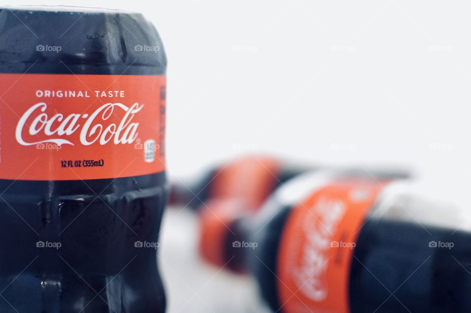Three plastic bottles of Coca-Cola on a white background