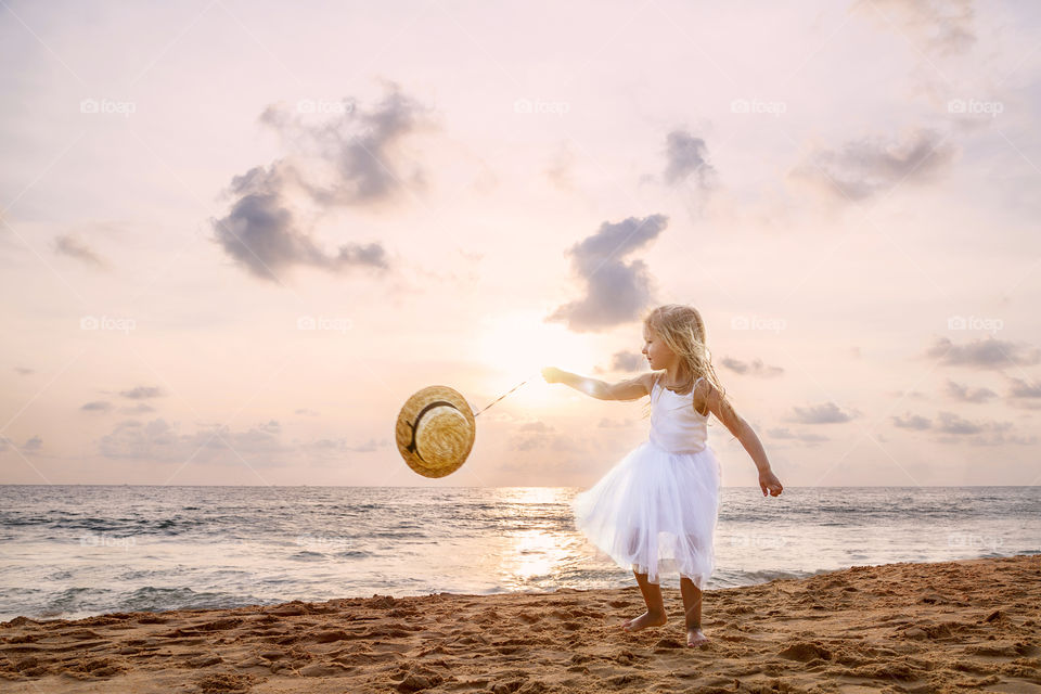 Cute little girl with blonde hair on the beach 