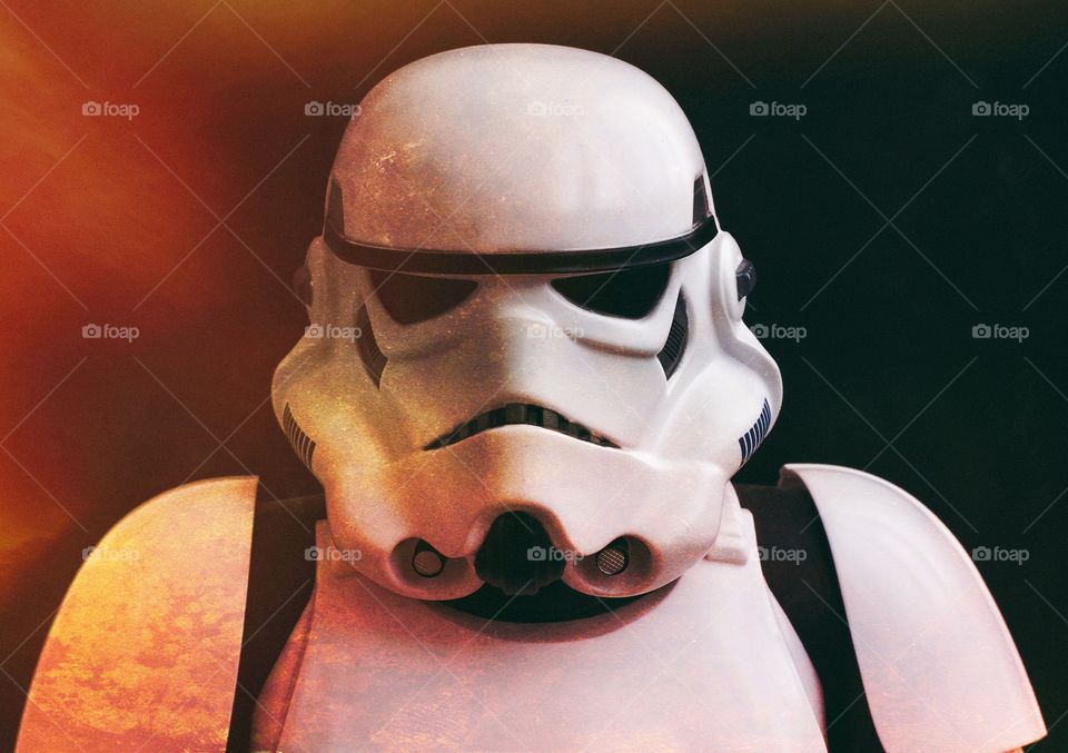 A Star Wars Stormtrooper looking directly at the camera in a flame filled scene.